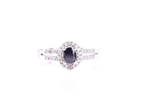 Lot 865 - A sapphire and diamond cluster ring, the oval...