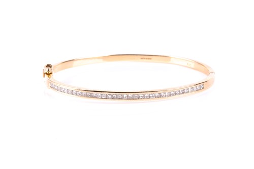 Lot 748 - An 18ct gold and diamond bangle, the front set...