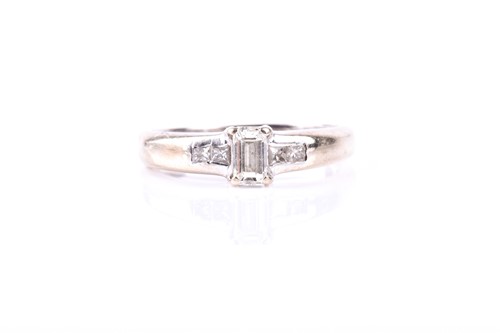 Lot 404 - A baguette diamond ring, the central baguette...