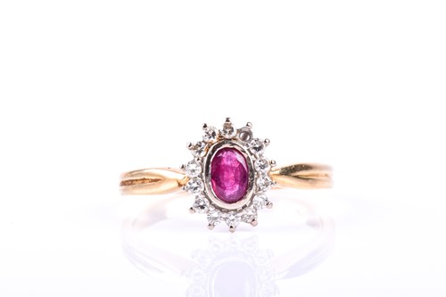 Lot 532 - A ruby and diamond cluster ring, the oval cut...