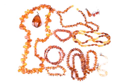 Lot 457 - A group of four pressed amber necklaces,...