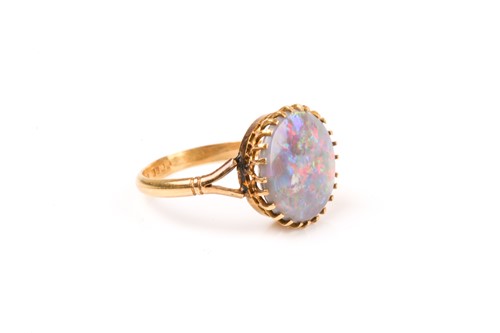 Lot 854 - A yellow gold and opal ring, set with a round...