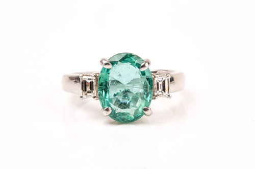 Lot 917 - A platinum, diamond, and emerald ring set with...