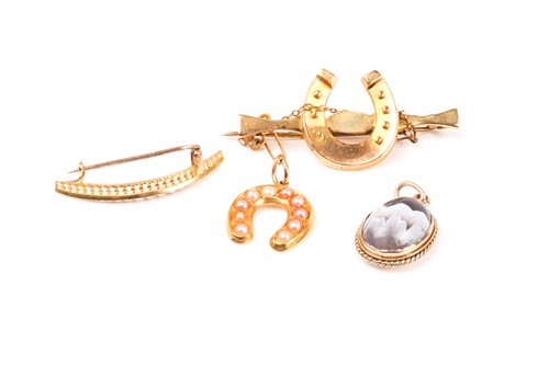 Lot 696 - A yellow metal and pearl horseshoe pendant,...