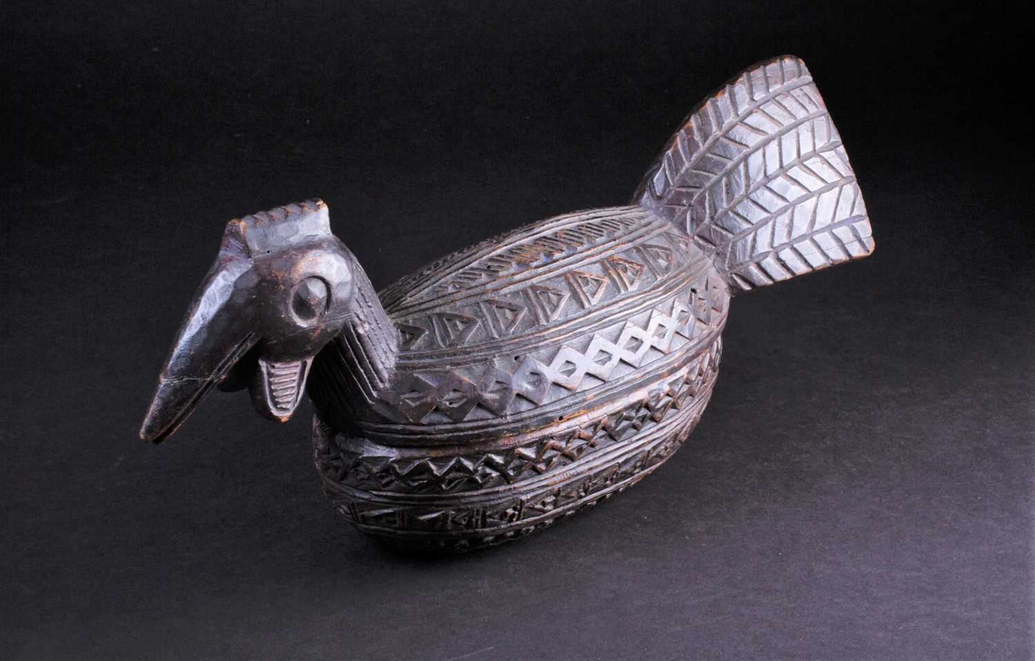 Lot 19 - A Yoruba carved wood box in the form of a bird,...