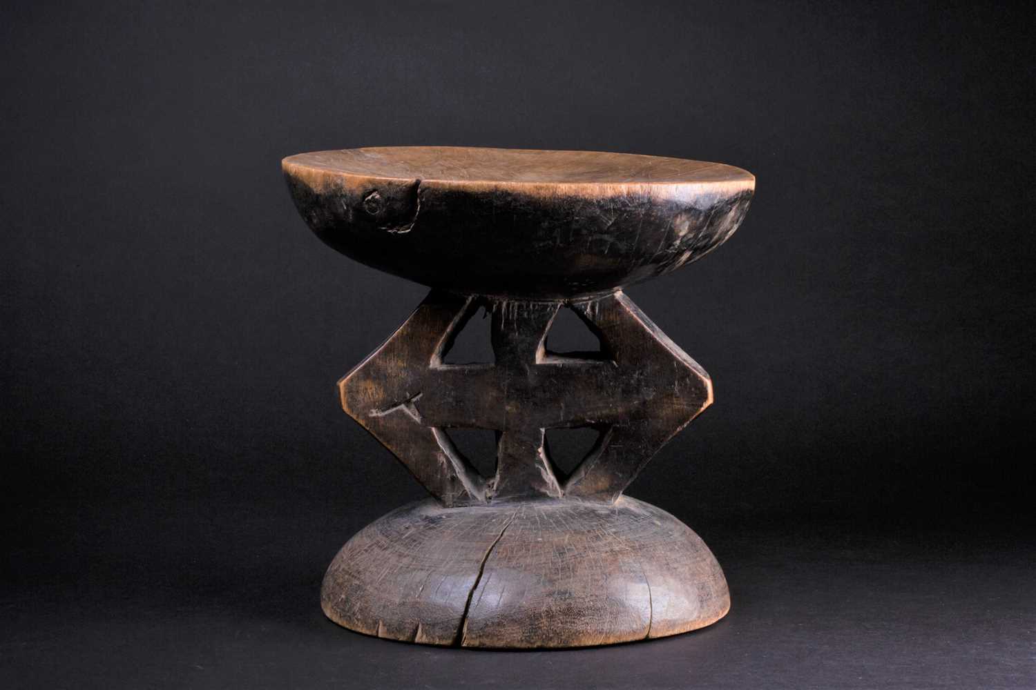 Lot 61 - An African carved wood stool, with a slightly...