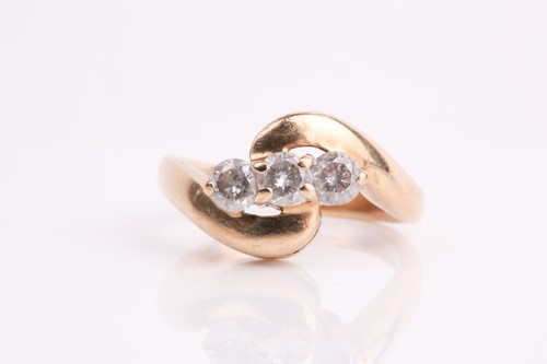 Lot 62 - A three stone diamond crossover ring, the...