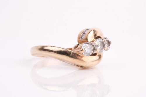 Lot 62 - A three stone diamond crossover ring, the...