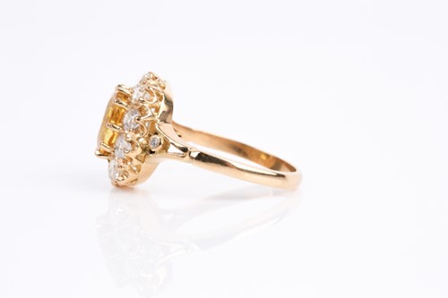 Lot 68 - A yellow sapphire and diamond cluster ring,...