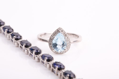 Lot 221 - A 9ct white gold, diamond, and blue topaz ring,...