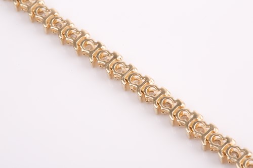 Lot 66 - A yellow gold and diamond bracelet, set with...