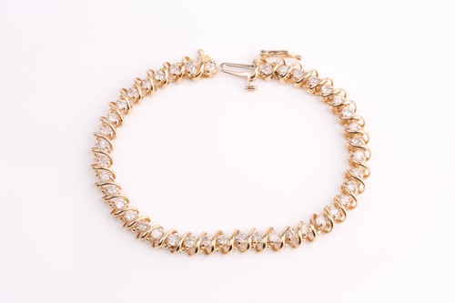 Lot 330 - A yellow metal and diamond line bracelet, the...