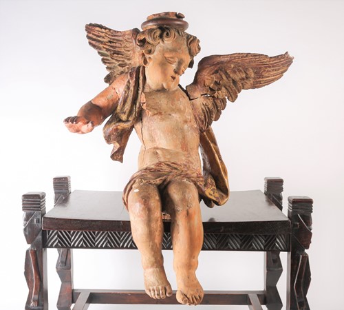 Lot 339 - A painted and carved-wood winged cherub,...