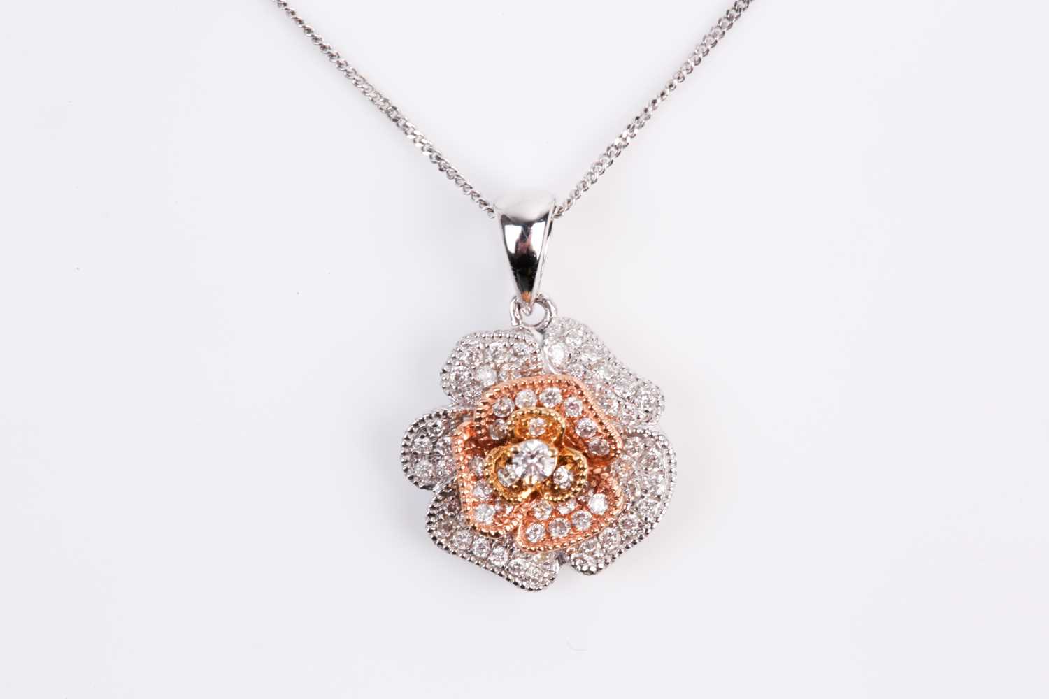 Lot 69 - A two colour 18ct gold and diamond flower head...