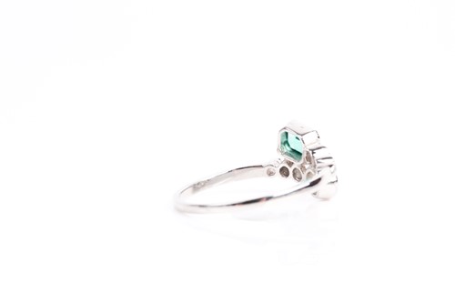 Lot 16 - An emerald and diamond crossover ring, with...