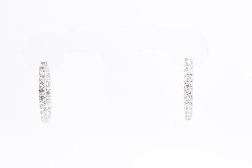 Lot 54 - A fine pair of diamond earrings, each set with...