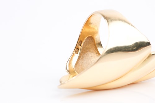 Lot 65 - A yellow metal elongated ring, of swept design,...