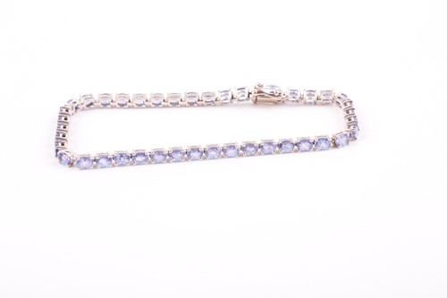 Lot 132 - An 18ct white gold and tanzanite line bracelet,...