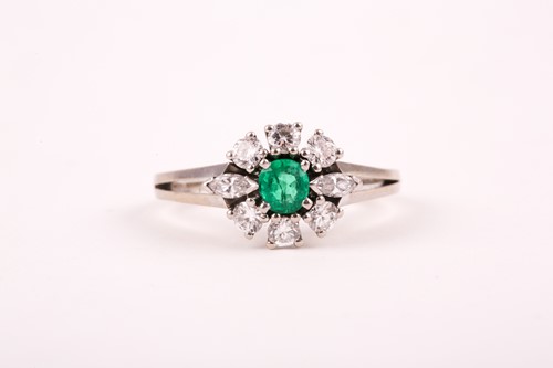 Lot 216 - An 18ct white gold, diamond, and emerald ring,...