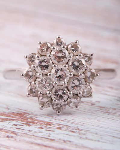 Lot 81 - A diamond cluster ring, the tired three row...