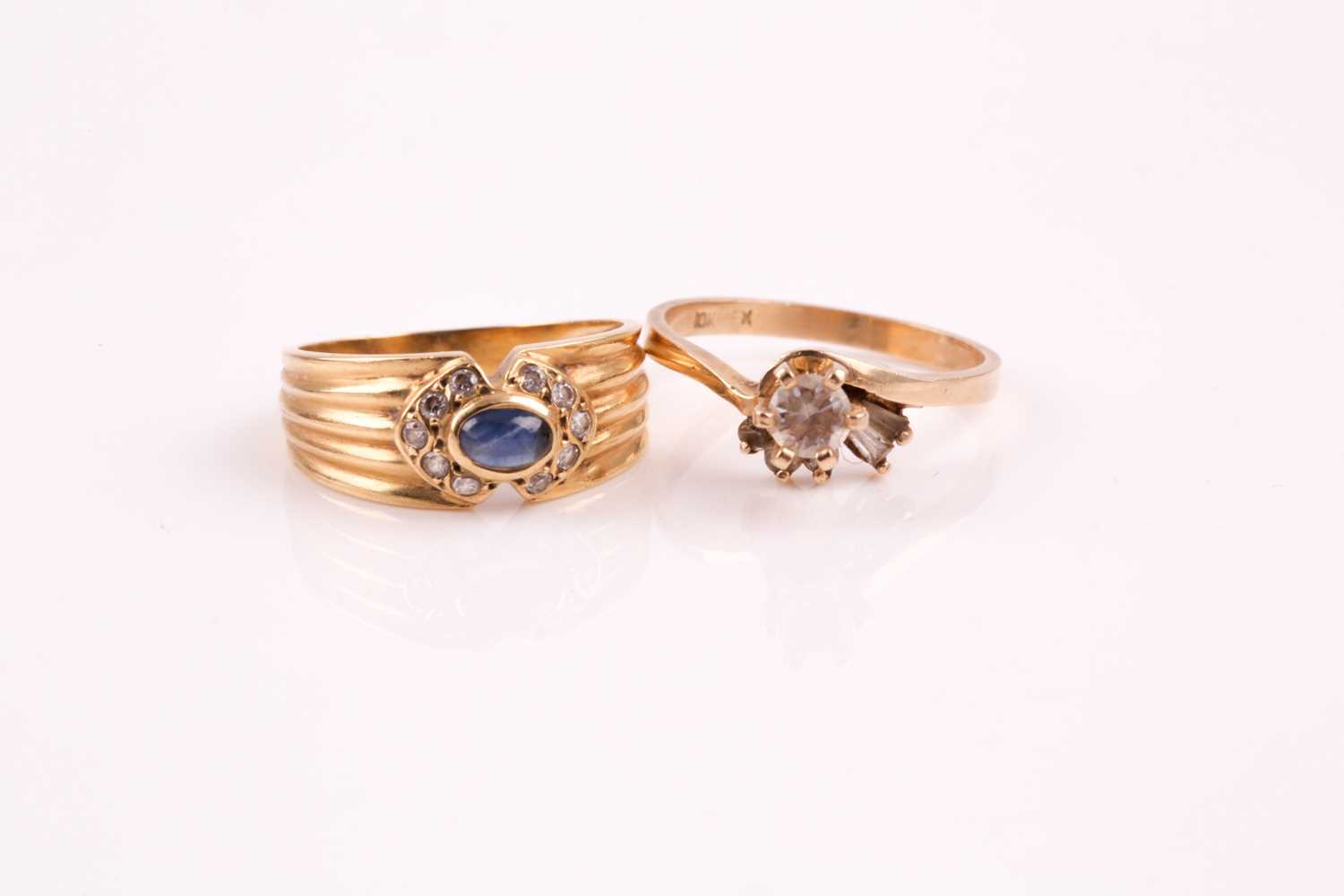 Lot 15 - A cabochon sapphire and clear stone ring, in a...