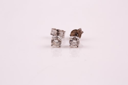 Lot 57 - A pair of diamond stud earrings; the round...