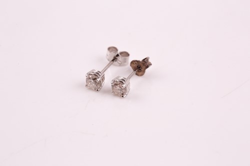 Lot 57 - A pair of diamond stud earrings; the round...