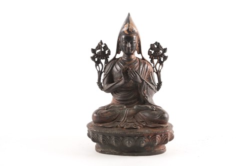 Lot 87A - A Tibetan patinated and gilt bronze figure of...