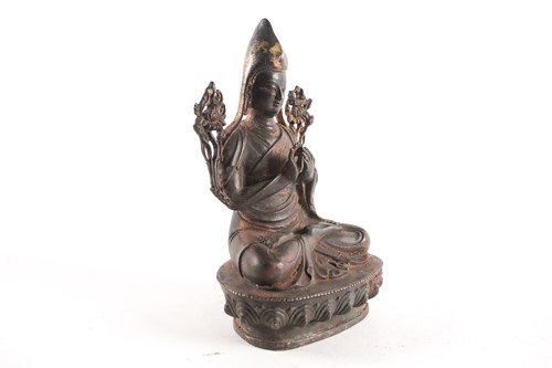 Lot 87 - A Tibetan patinated and gilt bronze figure of...