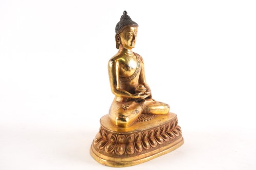 Lot 186 - A Sino Tibetan gilt-bronze figure of a seated...