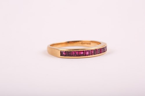 Lot 353 - An 18ct yellow gold and ruby ring, channel-set...