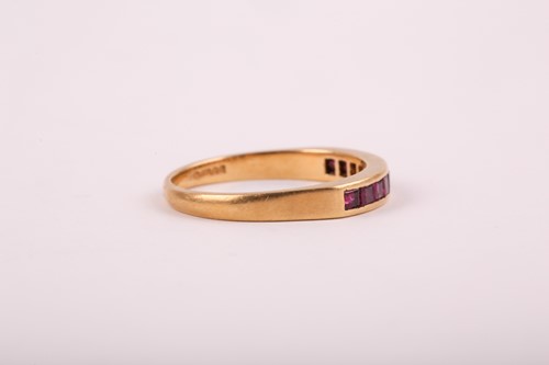 Lot 353 - An 18ct yellow gold and ruby ring, channel-set...