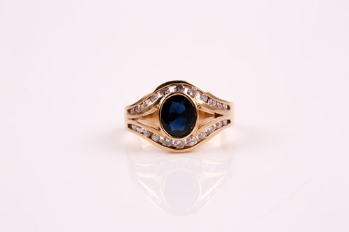 Lot 44 - A sapphire and diamond ring; the oval cut...