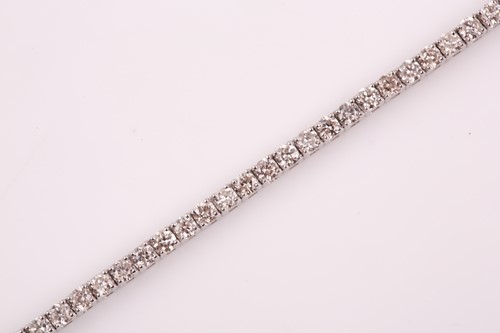 Lot 25 - An 18ct white gold and diamond line bracelet,...