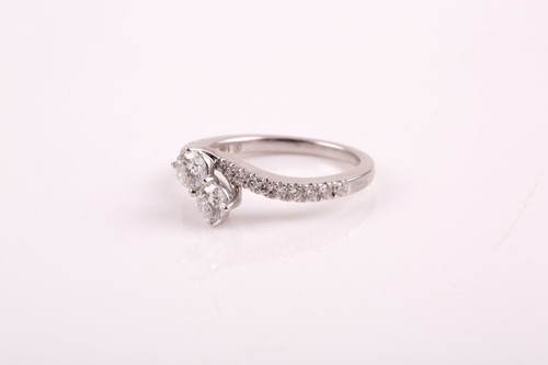 Lot 178 - A 14k white gold and diamond crossover ring,...