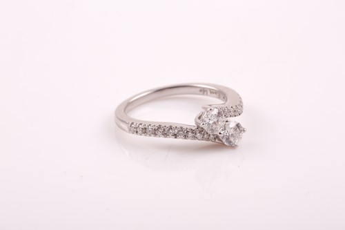Lot 178 - A 14k white gold and diamond crossover ring,...