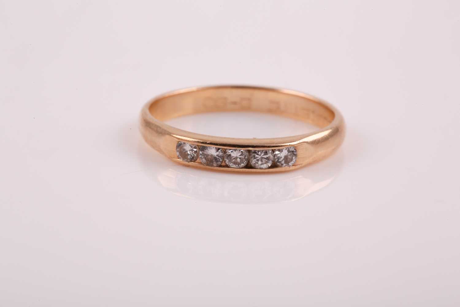 Lot 235 - A small yellow metal and diamond ring, channel-...