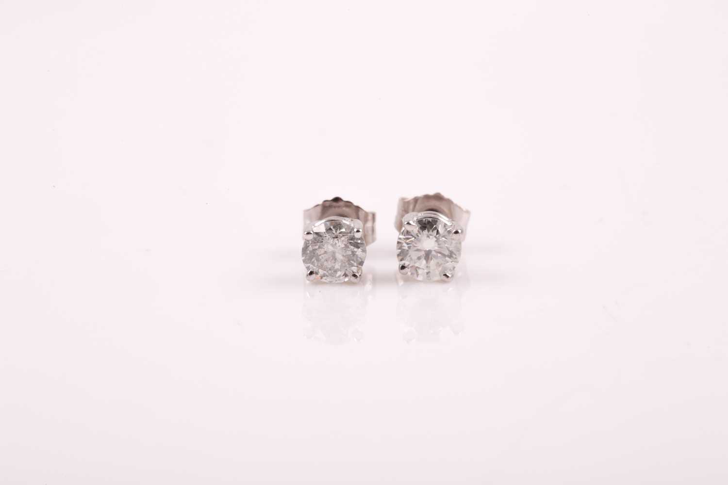 Lot 221 - A pair of solitaire diamond earrings, the...