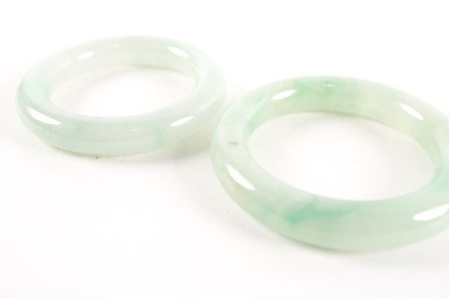 Lot 80 - A near pair of Chinese jade bangles, each...