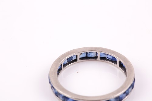 Lot 90 - A white metal and sapphire full eternity ring,...