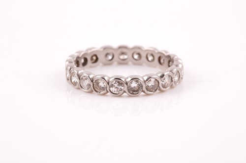 Lot 41 - A diamond eternity ring, rubover set with...