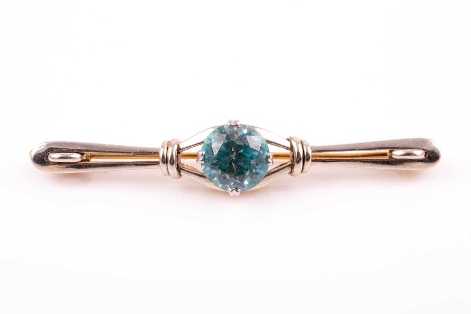 Lot 104 - A white and yellow gold and blue zircon brooch,...