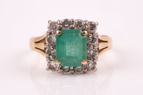 Lot 380 - An emerald and diamond cluster ring, the...