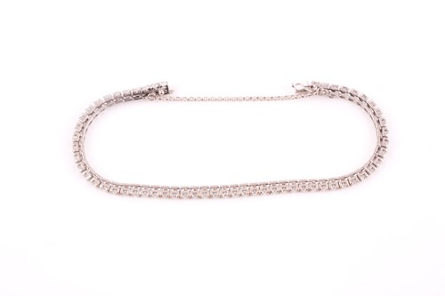 Lot 147 - A diamond line bracelet, set with round...