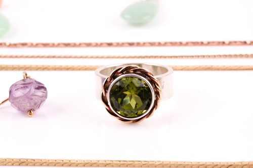 Lot 159 - A silver, gold, and peridot ring, size P,...