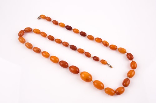 Lot 155 - A butterscotch amber beaded necklace, the...