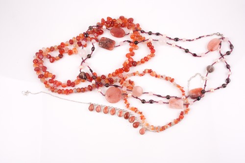 Lot 16 - A triple strand carnelian beaded necklace,...