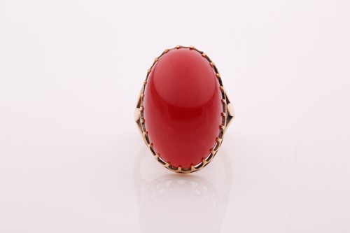 Lot 60 - A yellow metal and red coral ring, set with an...