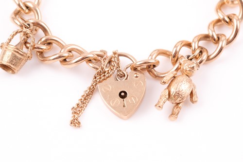 Lot 90 - A 9ct yellow gold curb-link charm bracelet,...