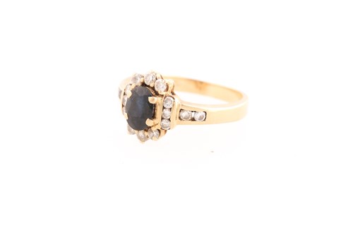 Lot 220 - A sapphire and diamond cluster ring; the...